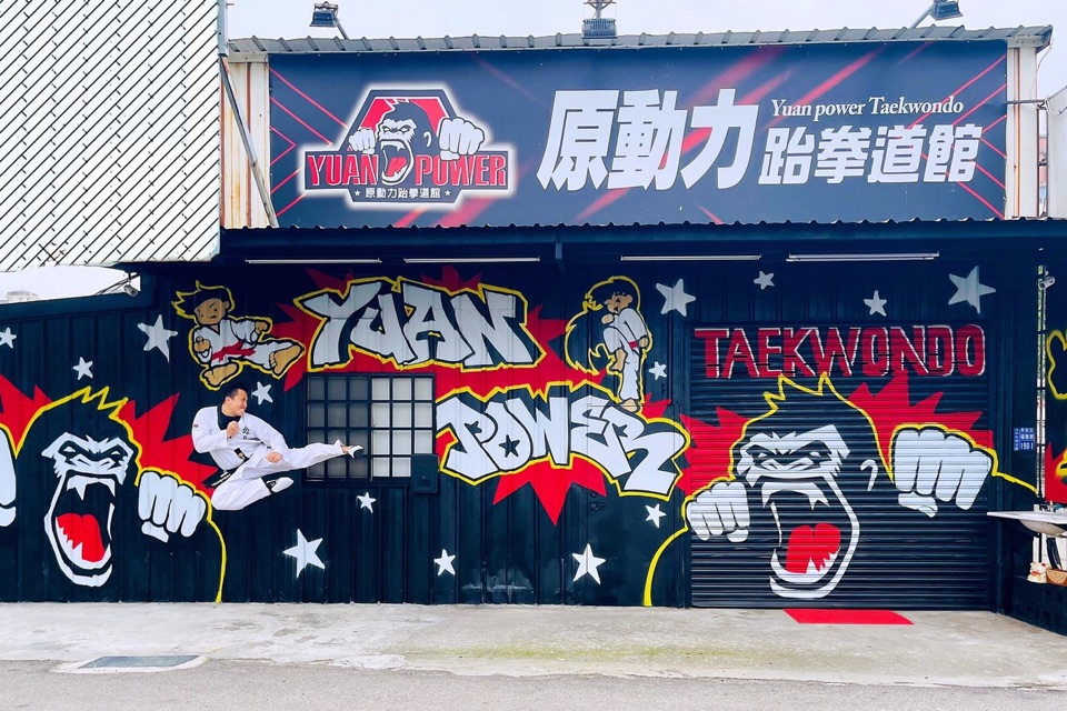 原動力跆拳道館現在的門面,黑色外牆繪有 YUAN POWER 大猩猩塗鴉,館長袁明哲於牆前騰空側踢
